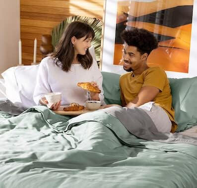 Couple enjoying breakfast in bed on DreamCool™ cooling sheets made from eucalyptus-based TENCEL™ Lyocell